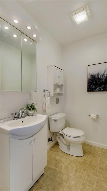 27183 250th St, Holcombe, WI 54745 - bathroom with toilet, vanity, baseboards, and recessed lighting