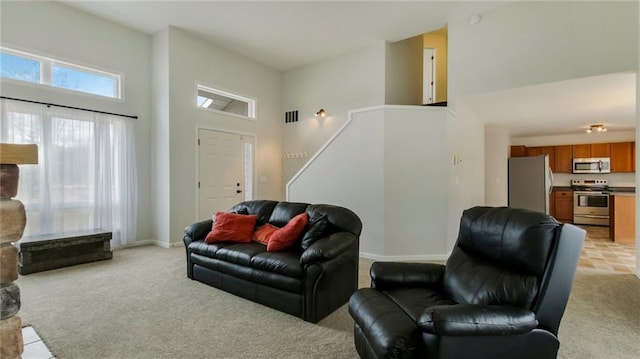 27183 250th St, Holcombe, WI 54745 - living area featuring baseboards, a towering ceiling, visible vents, and light colored carpet