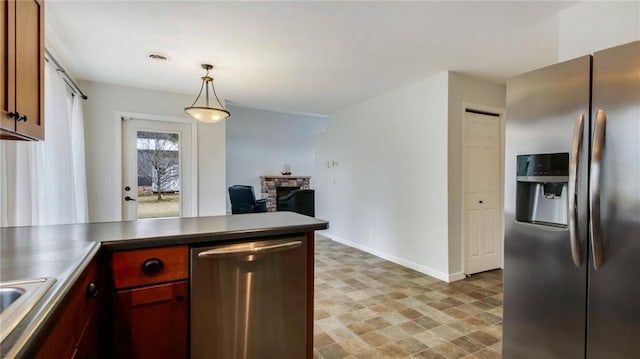 27183 250th St, Holcombe, WI 54745 - kitchen with stainless steel appliances, baseboards, hanging light fixtures, a peninsula, and a fireplace