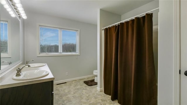 27183 250th St, Holcombe, WI 54745 - bathroom with double vanity, visible vents, toilet, and a sink