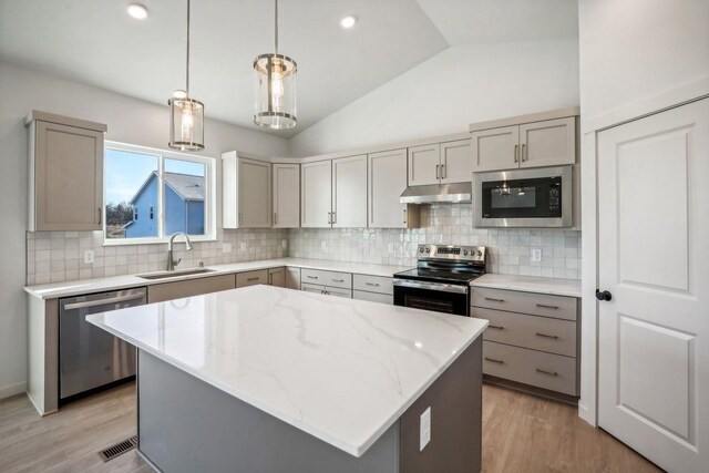 6608 Grouse Woods Rd, Deforest, WI 53532 - kitchen with gray cabinetry, under cabinet range hood, a sink, and stainless steel appliances