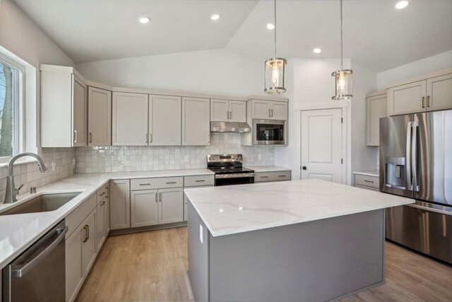 6608 Grouse Woods Rd, Deforest, WI 53532 - kitchen featuring lofted ceiling, stainless steel appliances, a center island, under cabinet range hood, and a sink