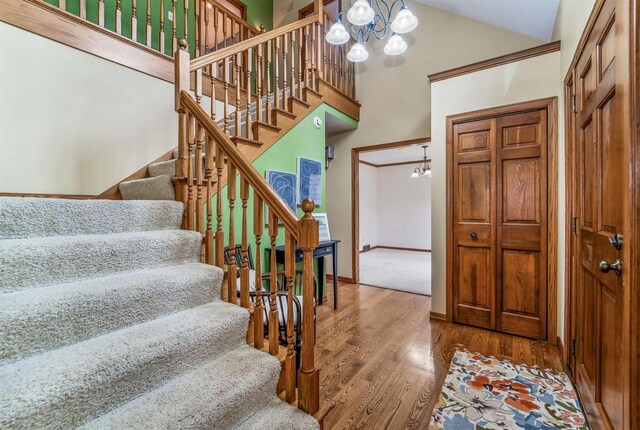 2015 Hickory Ln, Oshkosh, WI 54901 - foyer featuring high vaulted ceiling, a chandelier, wood finished floors, stairs, and baseboards