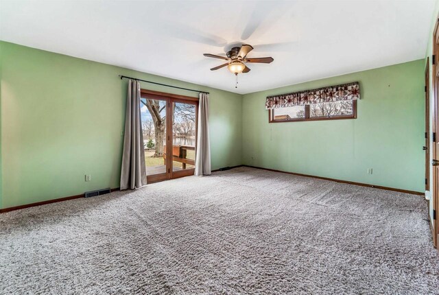 2015 Hickory Ln, Oshkosh, WI 54901 - carpeted empty room featuring visible vents, baseboards, and a ceiling fan