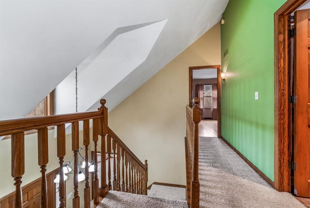 2015 Hickory Ln, Oshkosh, WI 54901 - stairway with visible vents, baseboards, vaulted ceiling, and carpet