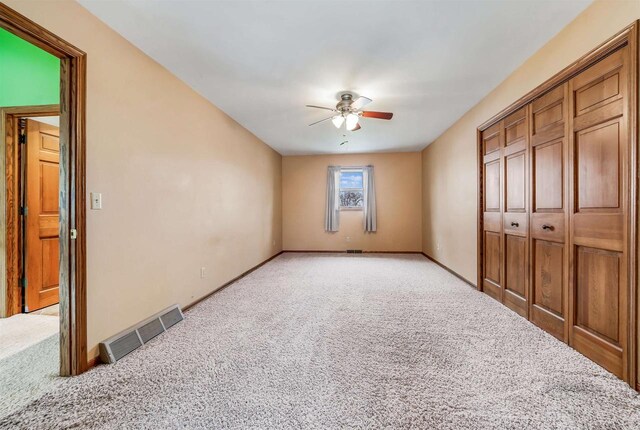 2015 Hickory Ln, Oshkosh, WI 54901 - unfurnished bedroom with visible vents, baseboards, ceiling fan, and light carpet