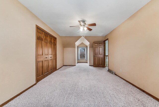 2015 Hickory Ln, Oshkosh, WI 54901 - interior space featuring ceiling fan, light colored carpet, vaulted ceiling, visible vents, and baseboards