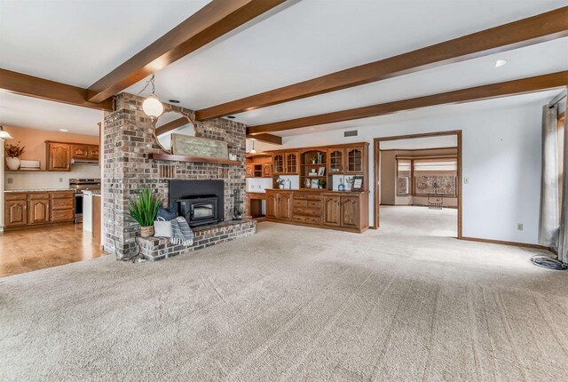 2015 Hickory Ln, Oshkosh, WI 54901 - unfurnished living room featuring beamed ceiling, a wood stove, visible vents, light carpet, and baseboards