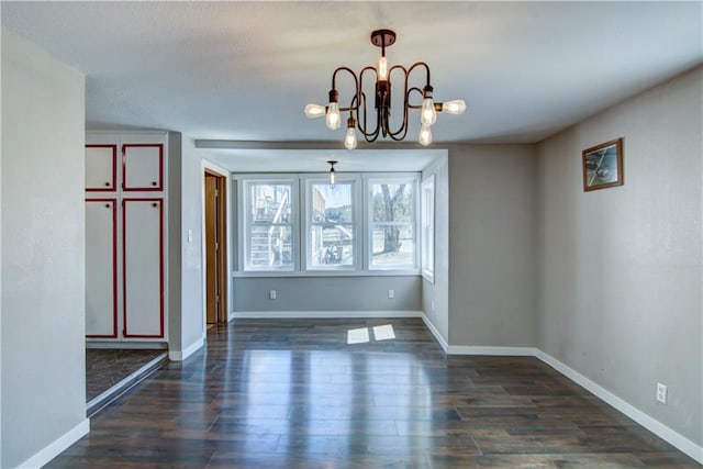 W1797 County Road A, Mindoro, WI 54644 - unfurnished dining area featuring baseboards, a notable chandelier, and dark wood-style floors