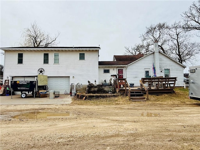 W1797 County Road A, Mindoro, WI 54644 - back of house featuring driveway, a wooden deck, and a garage
