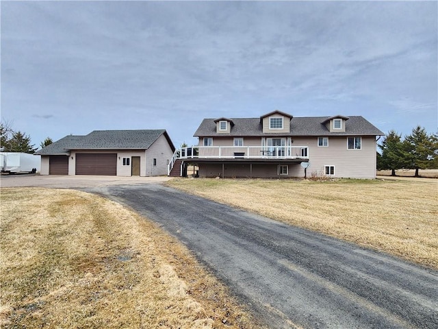 W9620 Hixwood Rd, Thorp, WI 54771 - view of front of home featuring a garage, driveway, a wooden deck, and a front lawn
