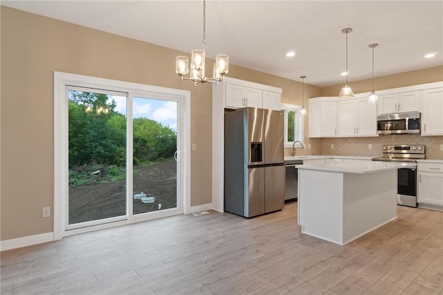 721 Jacko Ct, Hudson, WI 54016 - kitchen featuring white cabinetry, light countertops, tasteful backsplash, and appliances with stainless steel finishes