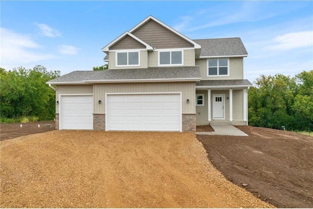 craftsman house featuring driveway and stone siding