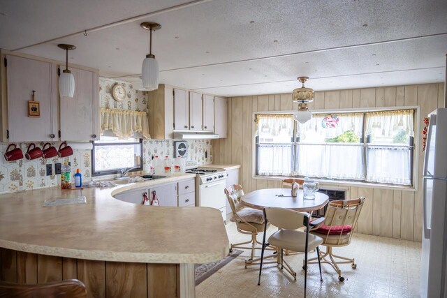 N7363 Wahneeta Ave, New Lisbon, WI 53950 - kitchen featuring light countertops, a sink, a peninsula, and white appliances