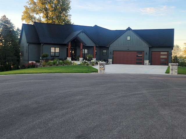 6612 Florance Ruth Ln, Sun Prairie, WI 53590 - view of front of home with concrete driveway, a garage, board and batten siding, a front yard, and stone siding