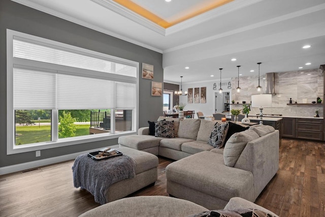 6612 Florance Ruth Ln, Sun Prairie, WI 53590 - living room featuring dark wood-type flooring, ornamental molding, recessed lighting, a tray ceiling, and a chandelier