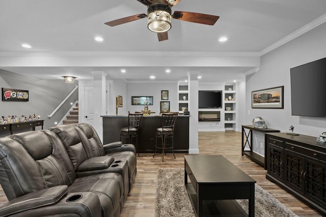 6612 Florance Ruth Ln, Sun Prairie, WI 53590 - living area featuring ornamental molding, bar area, light wood-style flooring, a ceiling fan, and built in shelves