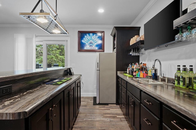 6612 Florance Ruth Ln, Sun Prairie, WI 53590 - indoor bar with freestanding refrigerator, light wood finished floors, crown molding, hanging light fixtures, and baseboards