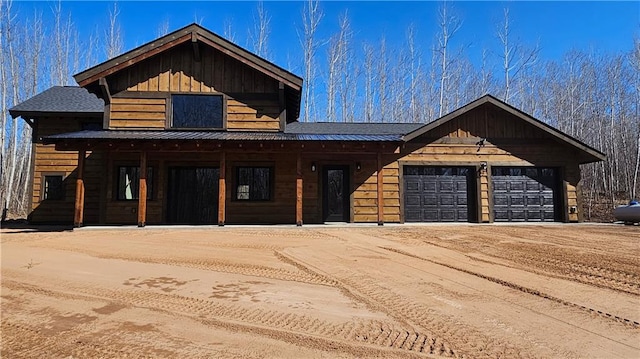 11960 US Highway 63, Hayward, WI 54843 - view of front of house featuring covered porch, a garage, dirt driveway, and metal roof