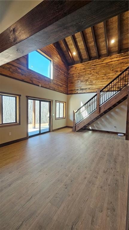 11960 US Highway 63, Hayward, WI 54843 - unfurnished living room with beam ceiling, baseboards, wood finished floors, and high vaulted ceiling