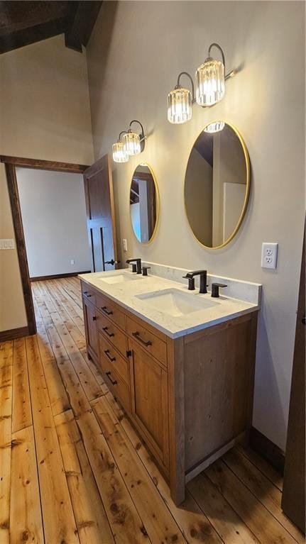 11960 US Highway 63, Hayward, WI 54843 - bathroom featuring double vanity, lofted ceiling with beams, wood-type flooring, and a sink