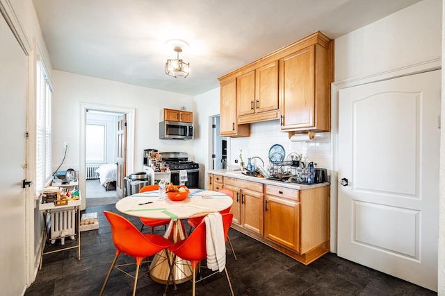 kitchen featuring a sink, light countertops, decorative backsplash, and appliances with stainless steel finishes
