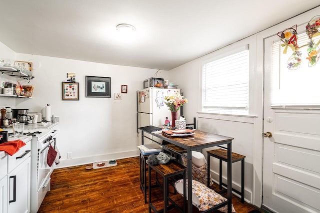 dining area featuring baseboards and dark wood finished floors