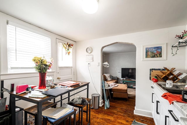 dining room with arched walkways and dark wood-style floors