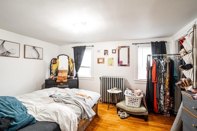 bedroom with radiator and wood finished floors