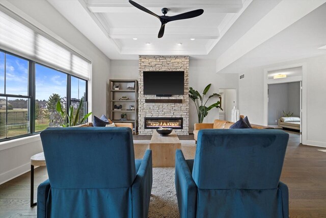 living room featuring a fireplace, a ceiling fan, wood finished floors, baseboards, and beam ceiling