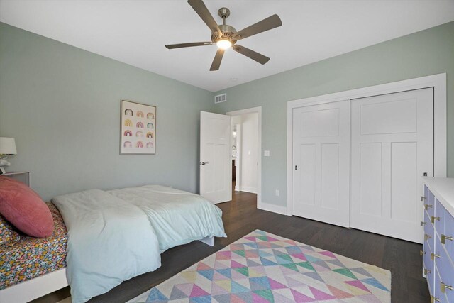bedroom featuring visible vents, a closet, baseboards, ceiling fan, and dark wood-type flooring