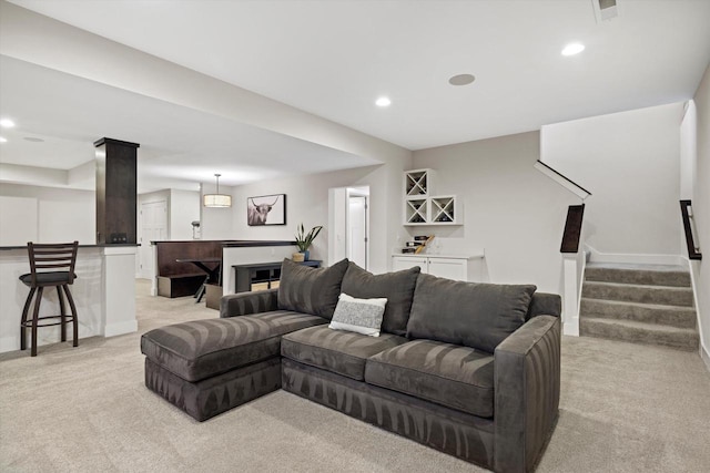 living room featuring a bar, recessed lighting, light colored carpet, and stairs