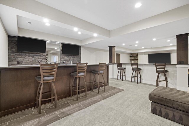 bar with recessed lighting, indoor wet bar, a tray ceiling, and backsplash