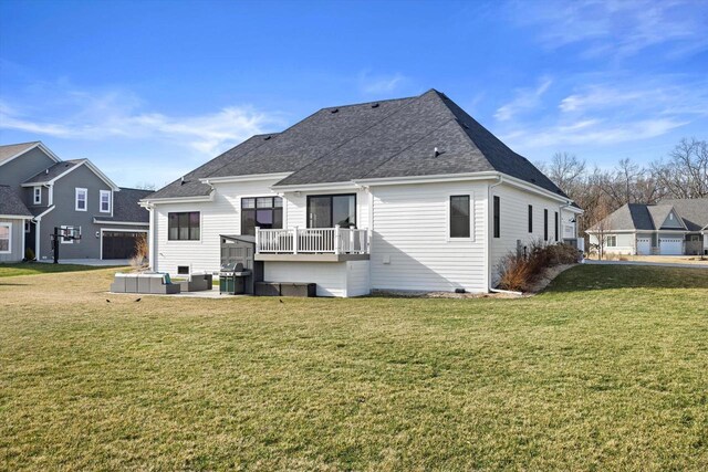 rear view of property featuring a patio, a lawn, and roof with shingles