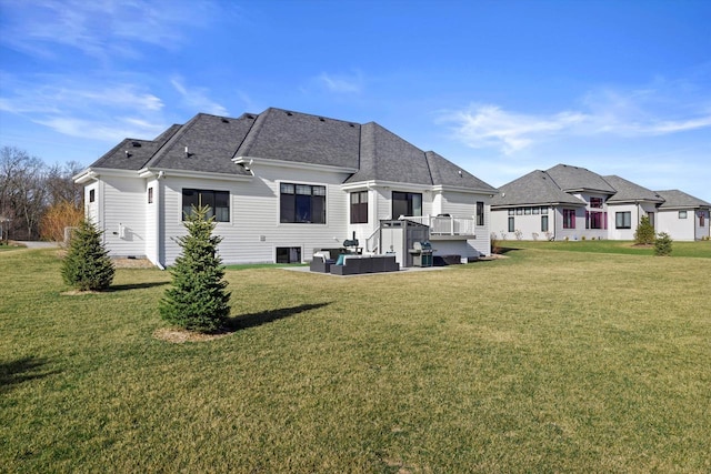 rear view of house with a wooden deck, a lawn, and roof with shingles