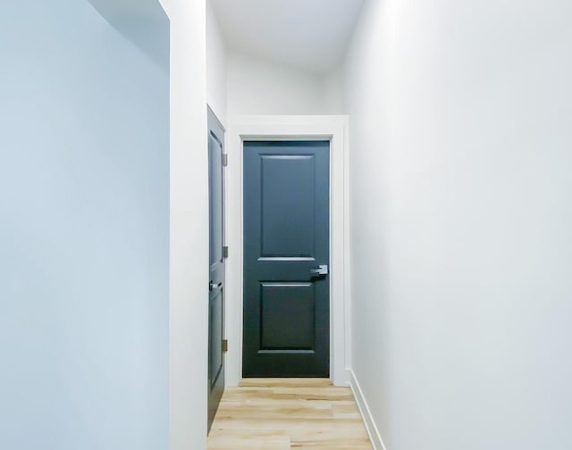 doorway to outside featuring light wood-style flooring and baseboards