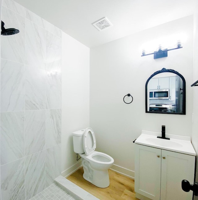full bathroom with vanity, baseboards, toilet, visible vents, and wood finished floors