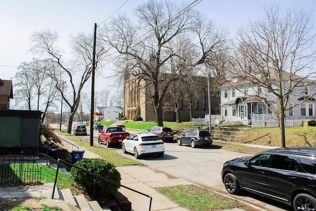 view of street with sidewalks, a residential view, and curbs