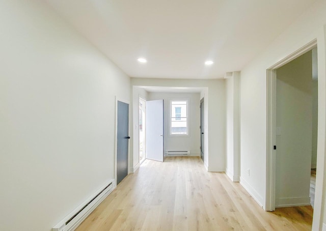 hall featuring baseboard heating, light wood-type flooring, baseboards, recessed lighting, and a baseboard radiator