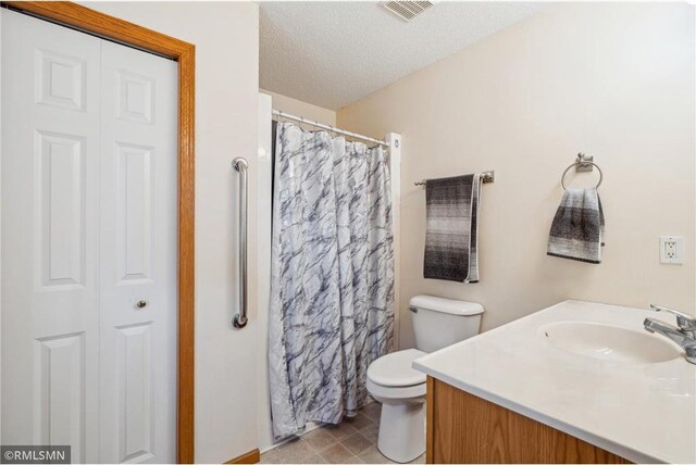 219 Bluff Dr, Somerset, WI 54025 - full bath featuring a textured ceiling, vanity, a shower with curtain, visible vents, and toilet