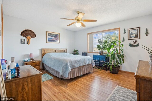 219 Bluff Dr, Somerset, WI 54025 - bedroom with light wood-style flooring, a textured ceiling, and ceiling fan