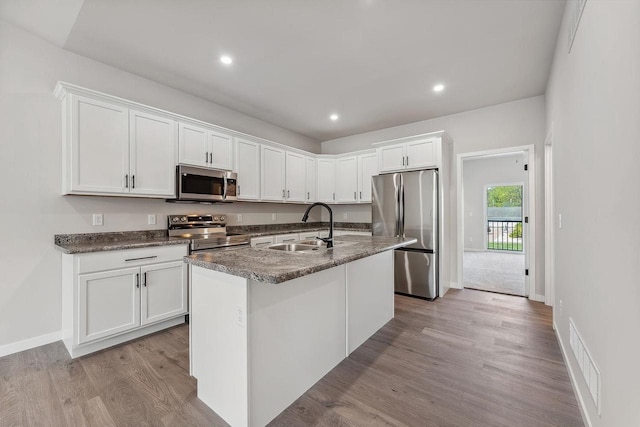 216 S Dewey Ave, Reedsburg, WI 53959 - kitchen featuring appliances with stainless steel finishes, a sink, white cabinets, light wood-type flooring, and recessed lighting