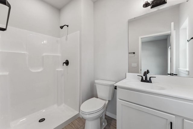 216 S Dewey Ave, Reedsburg, WI 53959 - full bathroom with toilet, a stall shower, wood finished floors, vanity, and baseboards