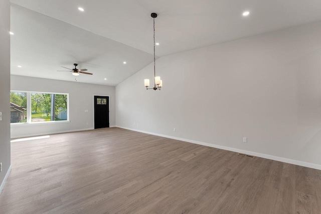 216 S Dewey Ave, Reedsburg, WI 53959 - spare room featuring a chandelier, a ceiling fan, vaulted ceiling, wood finished floors, and baseboards
