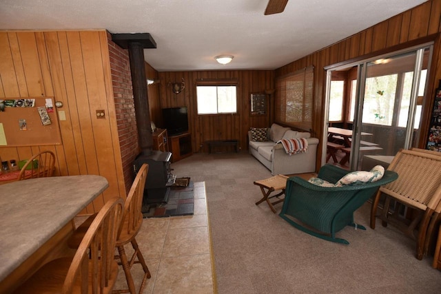 W1514 Spirit Ridge Trl, Keshena, WI 54135 - living area featuring a wood stove, wood walls, and ceiling fan