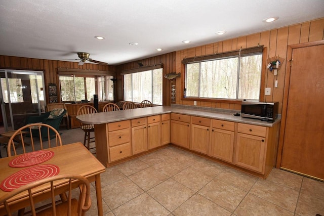 W1514 Spirit Ridge Trl, Keshena, WI 54135 - kitchen with stainless steel microwave, wooden walls, ceiling fan, recessed lighting, and light tile patterned floors