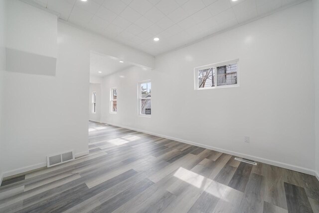 unfurnished room with recessed lighting, visible vents, baseboards, and wood finished floors