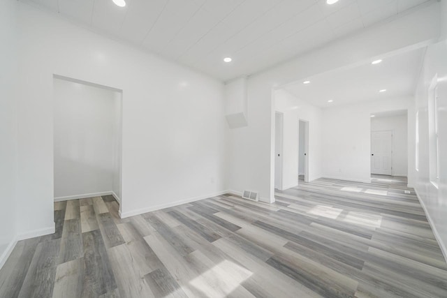 unfurnished room featuring wood finished floors, baseboards, visible vents, and recessed lighting