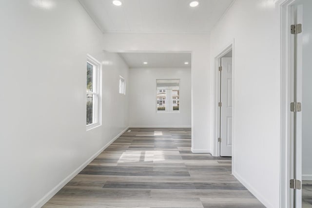 corridor featuring baseboards, recessed lighting, and wood finished floors