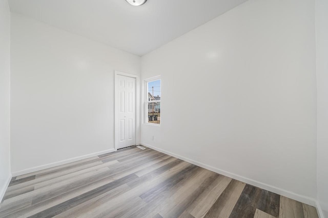 empty room with baseboards and wood finished floors